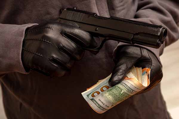 gloved hand holding pistol and money thumbnail